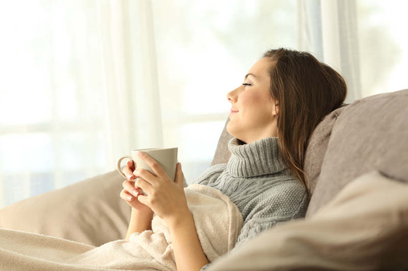 Blog Title: What Are Zone Control Systems? Photo: Woman relaxing on her couch